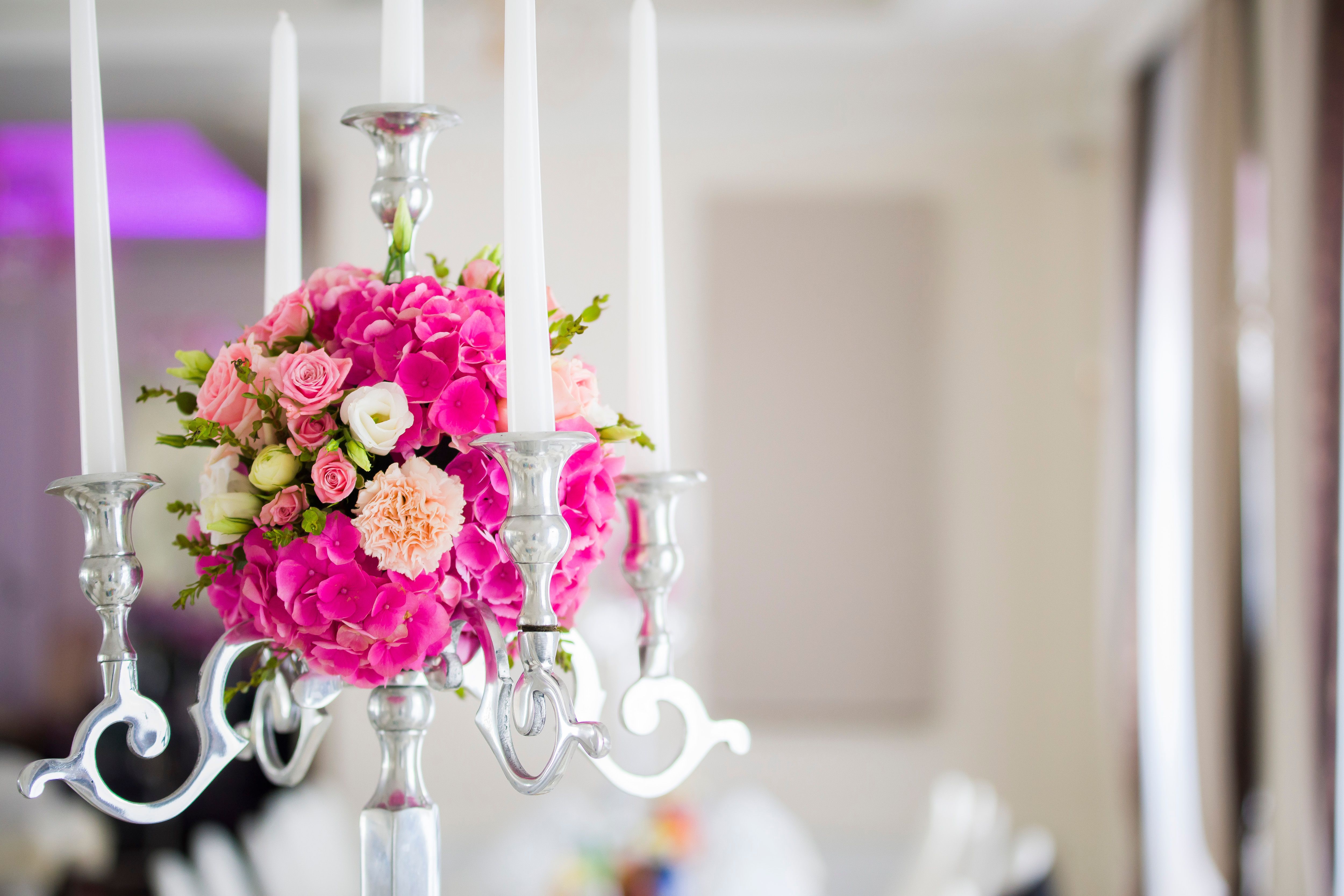 Pink hydrangea centerpiece with candles on decorative candelabra for wedding table decor