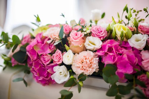 Bouquet of fresh flowers in white vessel