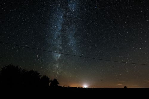 Free Picturesque scenery of starry night sky with milky way above trees and field in countryside Stock Photo