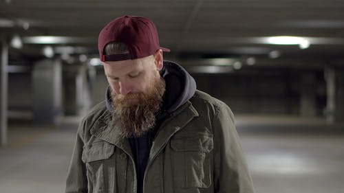 Man in Green Jacket Wearing Red Hat