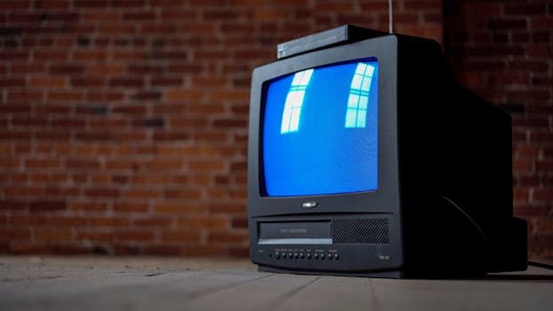 Old CRT television set with a blue screen in front of a rustic brick wall, evoking nostalgia.