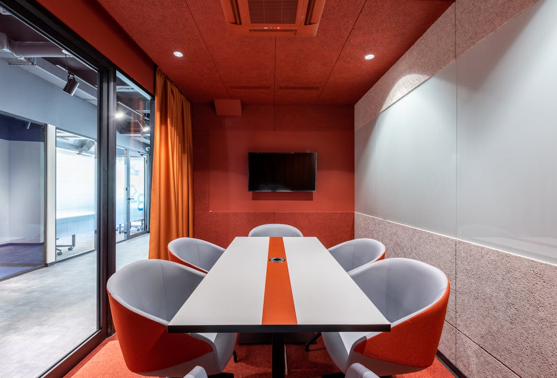 A modern workspace with large aluminum sliding doors and a red wall.
