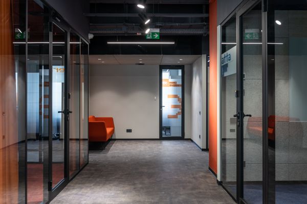 Modern office corridor with glass partitions and glass doors