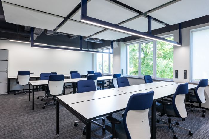Empty open-plan meeting room with long white tables — photo by Max Vakhtbovych on Pexels
