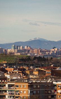 Urban skyline with distant mountains, capturing city life and nature blended together.