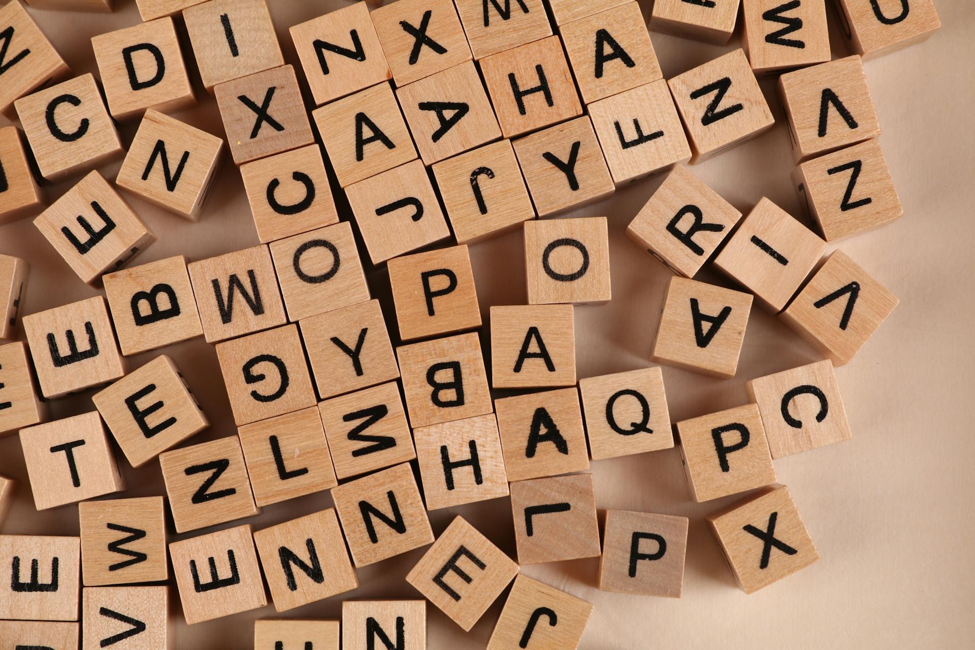 Close-up of scattered wooden alphabet blocks, ideal for educational and playful themes.