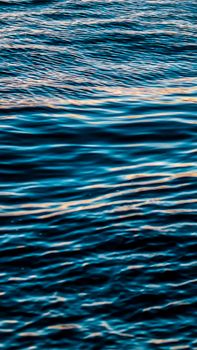 Tranquil view of ocean waves reflecting golden sunlight, perfect for serene backgrounds.
