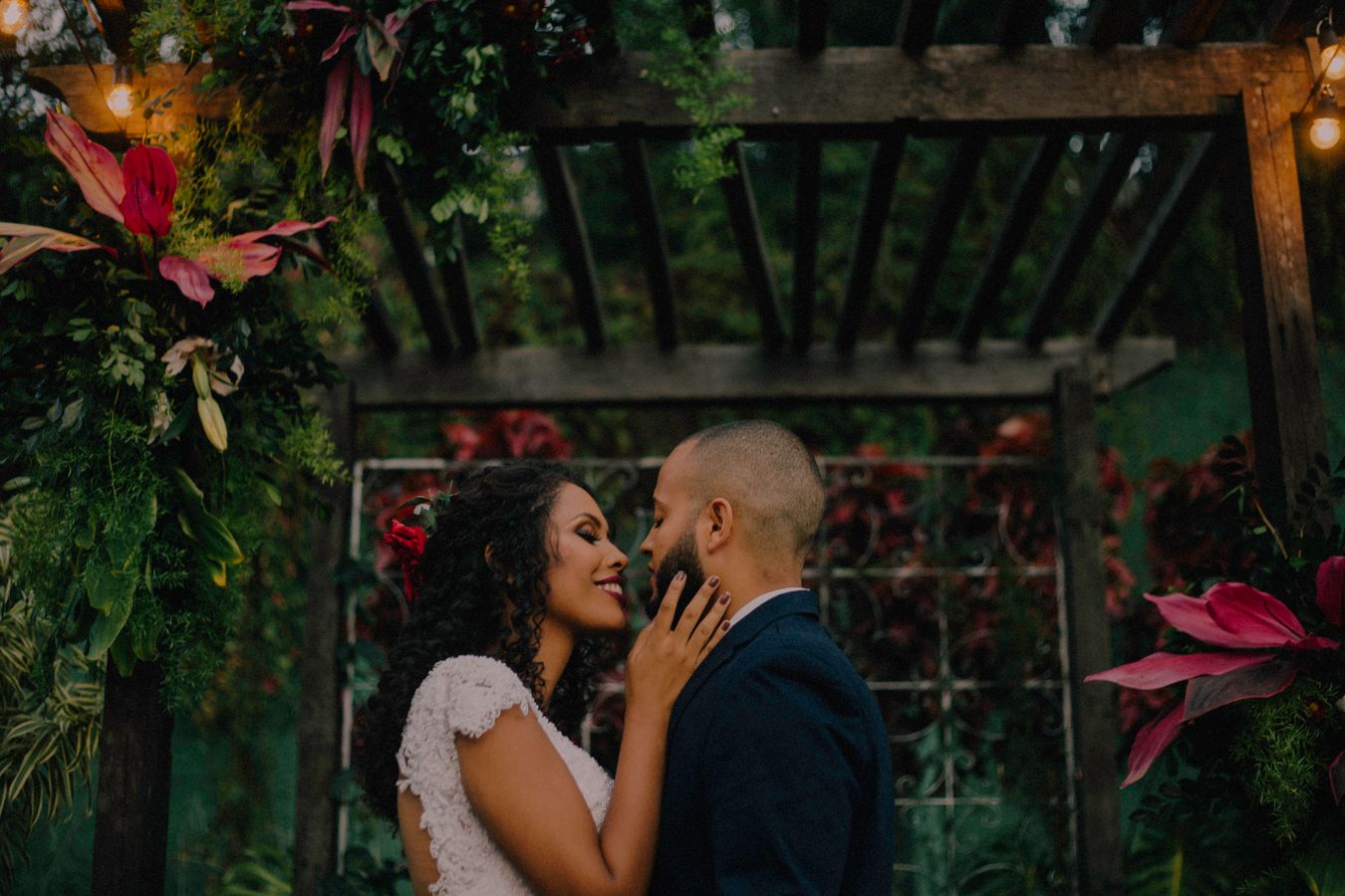 Pareja abrazada en un jardín íntimo con luces cálidas durante su boda