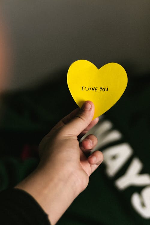 Free Photo of a Person's Hand Holding a Heart Shaped Paper Stock Photo