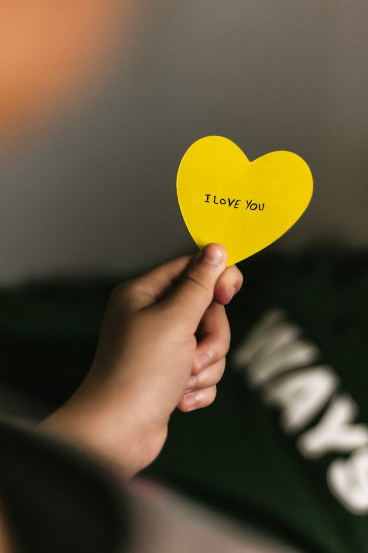 Hand Holding A Heart Shaped Paper With Message 