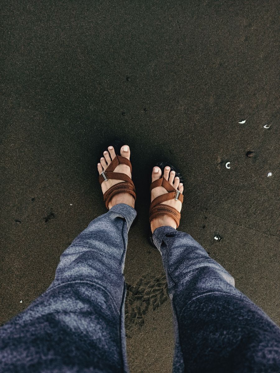 Feet in sandals on a sandy beach
