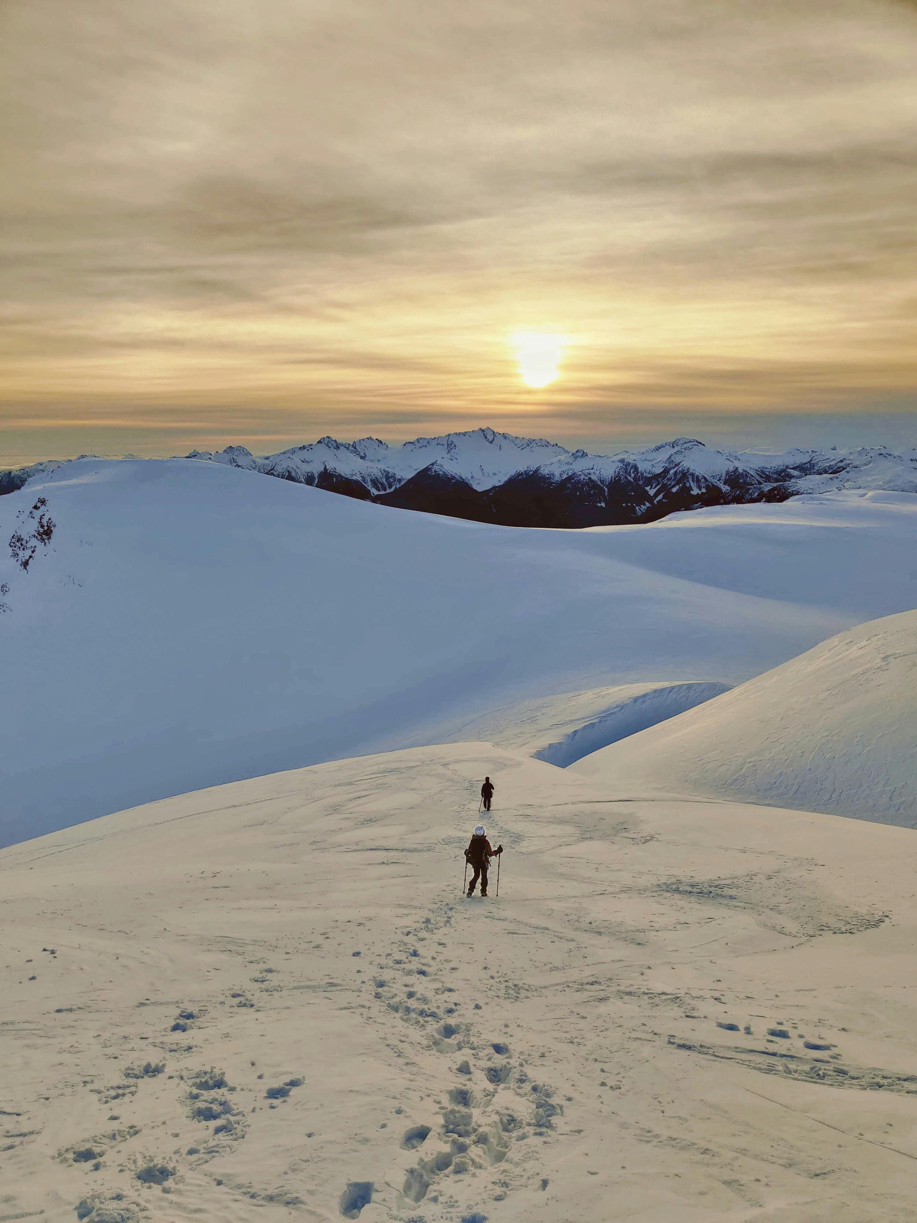 Aerial view of winter hikers traversing snowy mountain terrain using proper layering