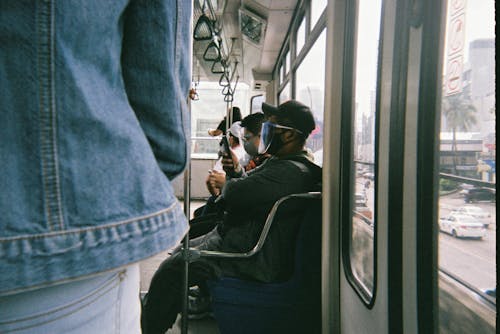 People Traveling on Public Transportation and Wearing Face Shields and Masks