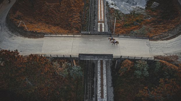Aerial Photo of Horse Riders Crossing the Bridge 