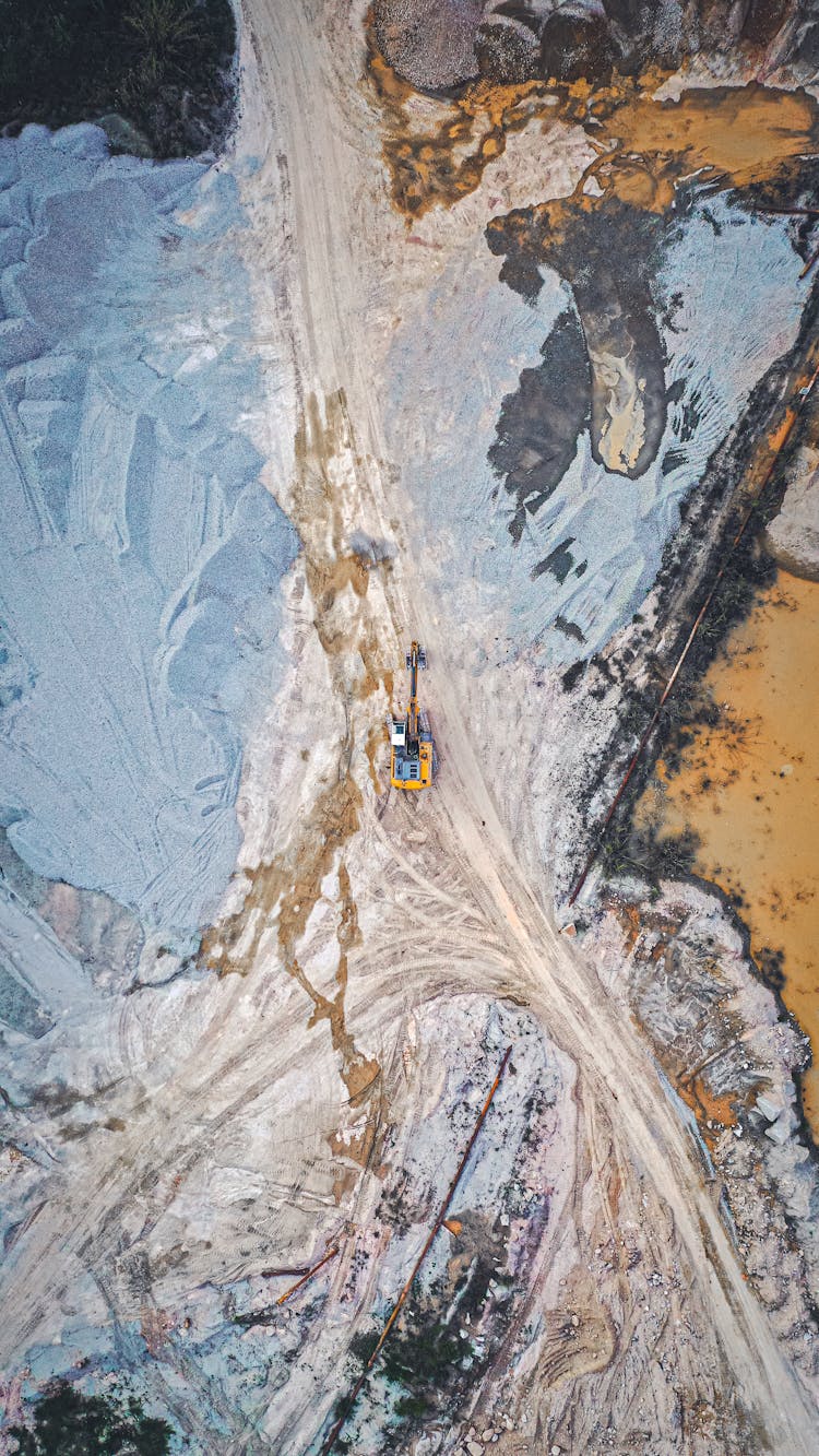 Drone Shot Of An Excavator Digging On A Road In Winter 