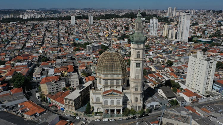 An Aerial Photography Of A Church Surrounded With Houses And Buildings