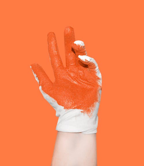 A Person Wearing White Glove with Orange Paint