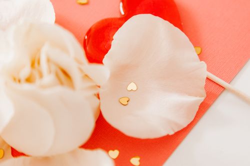 Free Close-up of heart-shaped lollipop with rose petals, sweet ambiance. Stock Photo