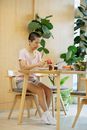 Focused ethnic woman peeling apple during lunch preparation at home