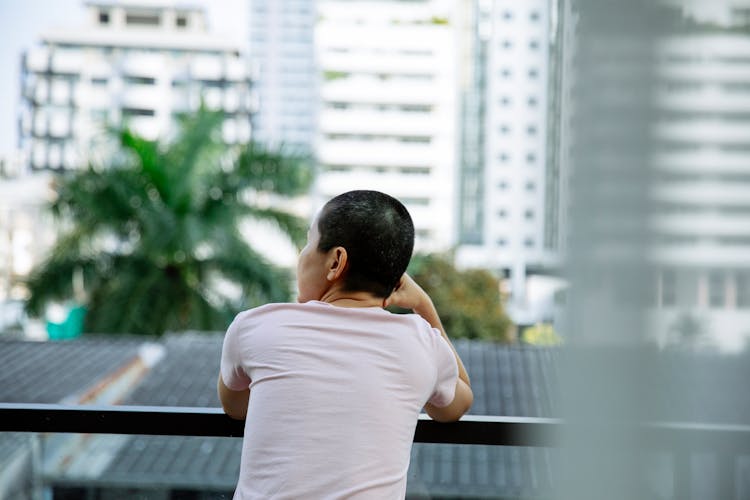 Person With Short Dark Hair Resting On Balcony