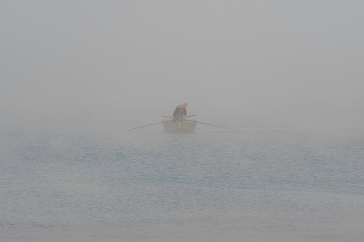 A Man Rowing A Boat In The Sea