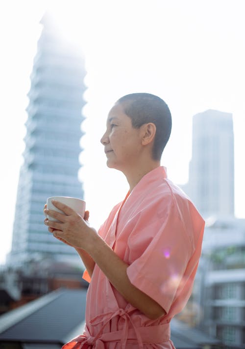 Sick Asian woman with hot cup of tea in morning