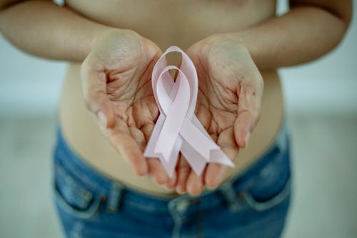 Faceless topless woman with pink ribbons against breast cancer