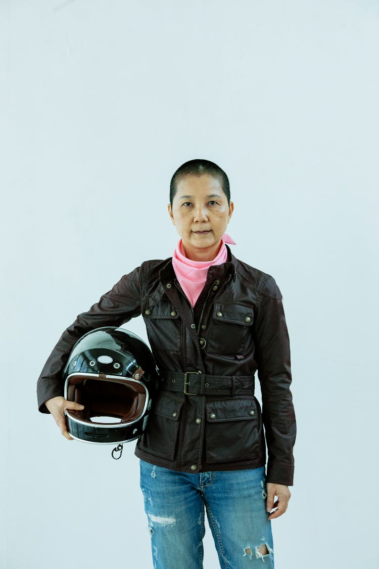 Cheerful Asian Woman Motorcyclist Standing In Studio