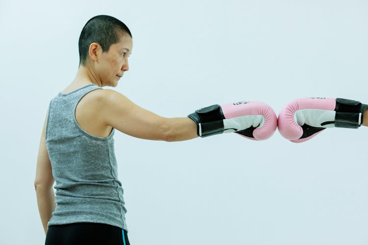 Serious Asian Lady In Pink Boxing Gloves In Studio