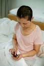 Ethnic woman sitting in bed while taking pills