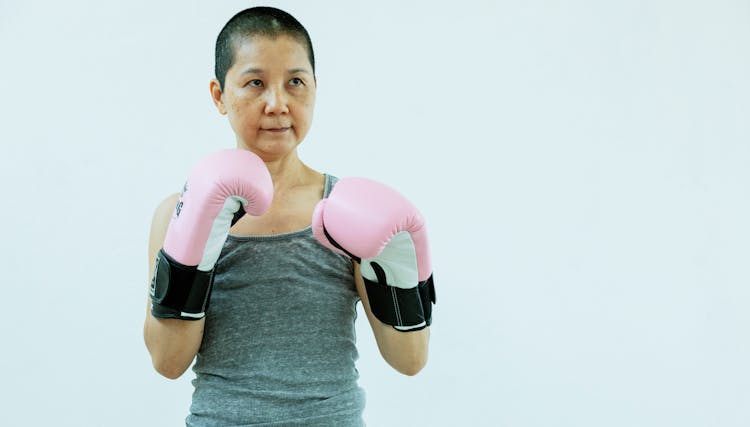 Serious Asian Female Boxer In Pink Boxing Gloves In Studio