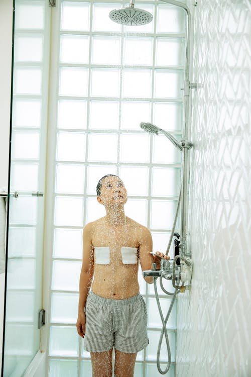Sick Asian woman with breast cancer under shower