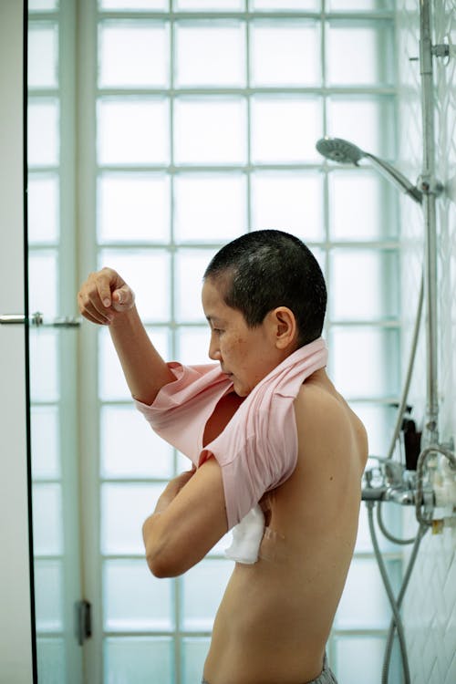 Side view of ethnic female with short hair and breast cancer wearing T shirt in bathroom