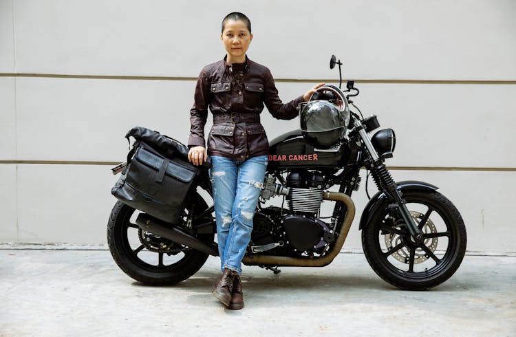 Serious Asian Lady Near Motorcycle In Street On Road