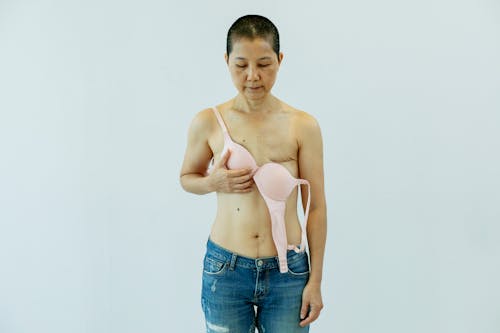 Asian woman in unfastened bra suffering from breast cancer