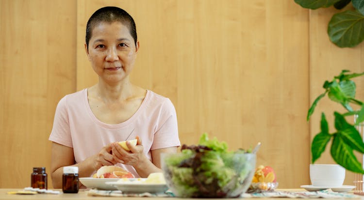 Sick Positive Asian Woman Having Breakfast At Table