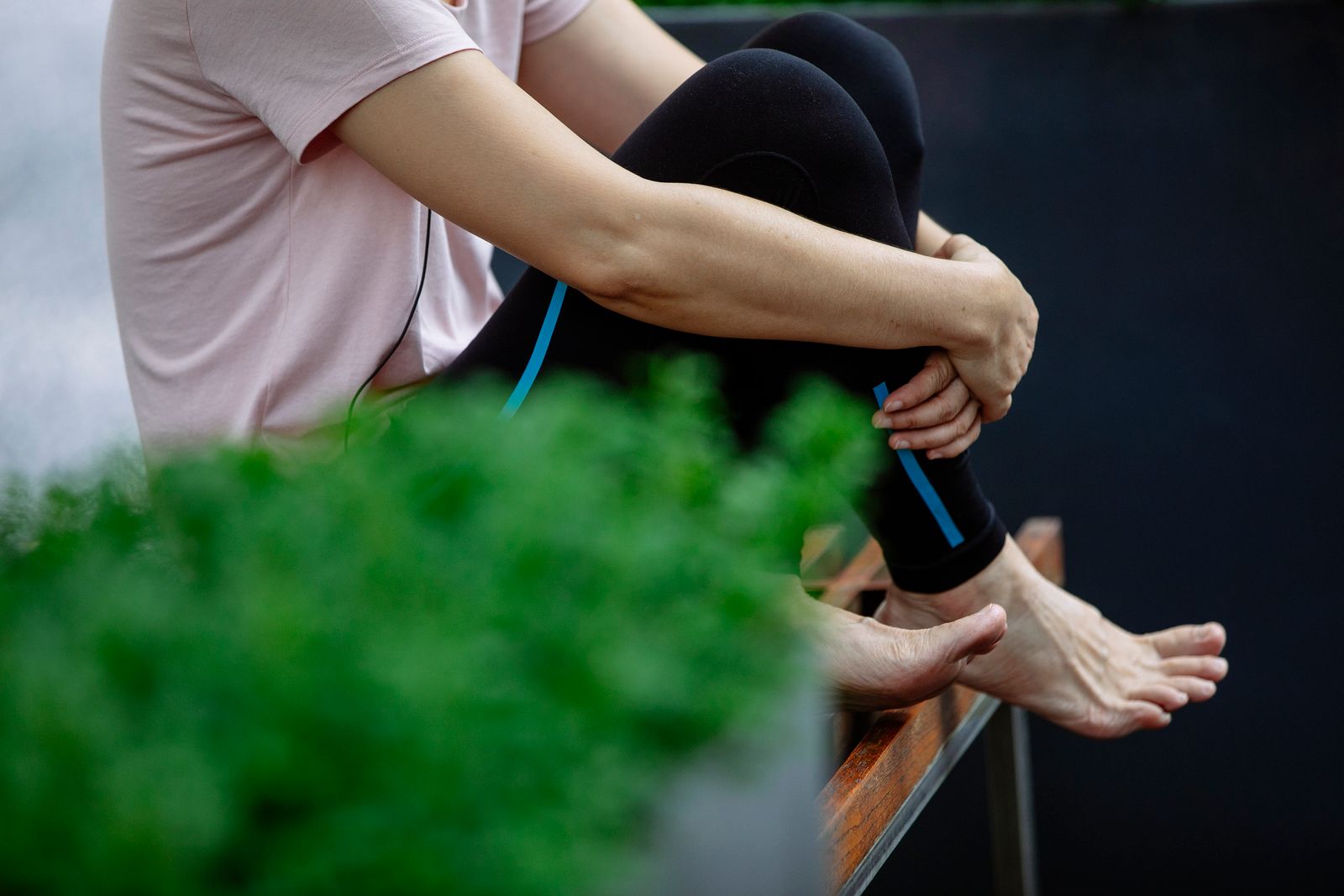 Runner stretching knee on a bright outdoor path