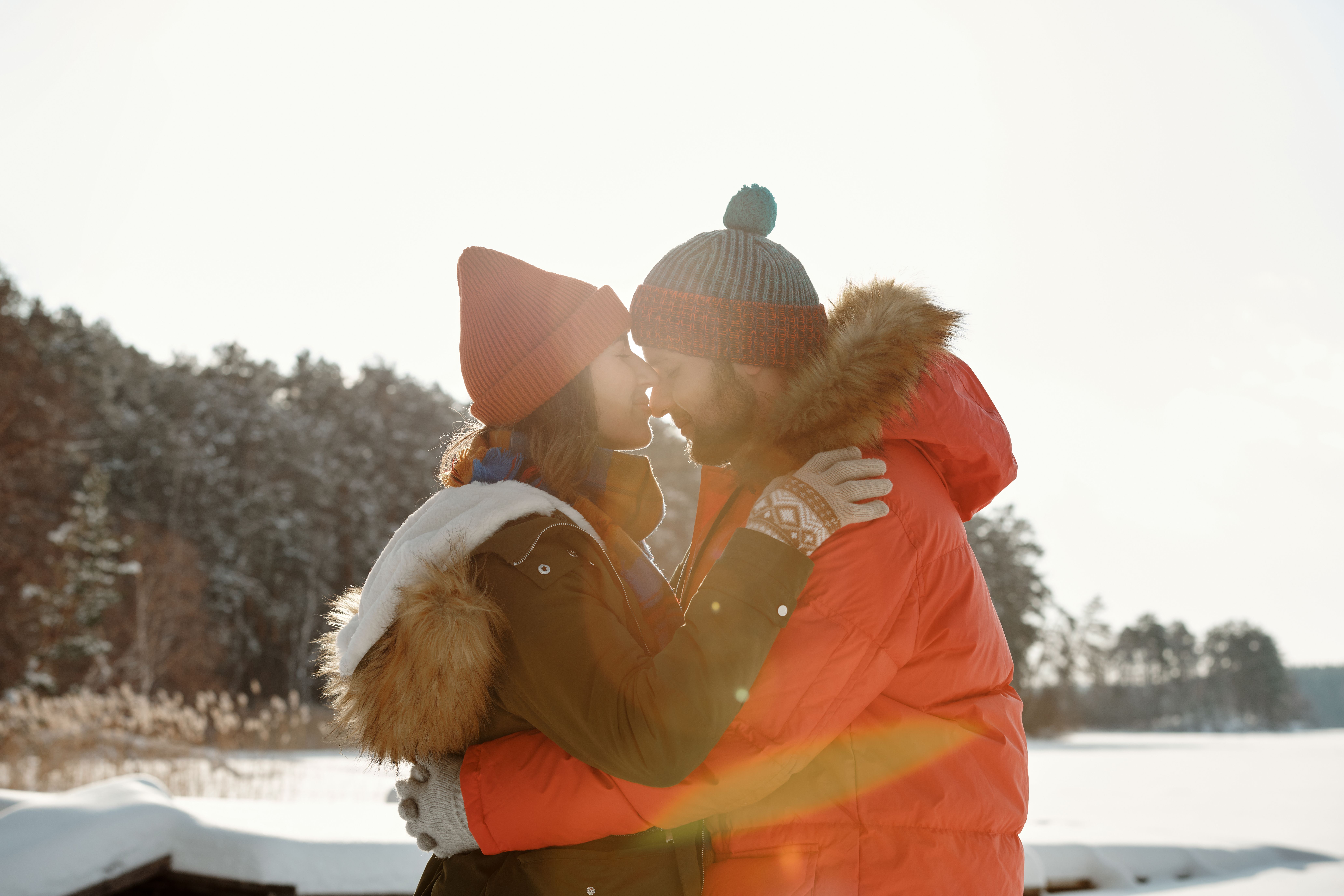 A young couple holding hands during the cold winter season, illustrating short-term seasonal dating trends on mobile apps.
