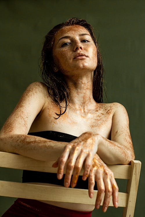 Free A Woman in Black Tube Top Sitting on Chair with Exfoliating Grains on Skin Stock Photo
