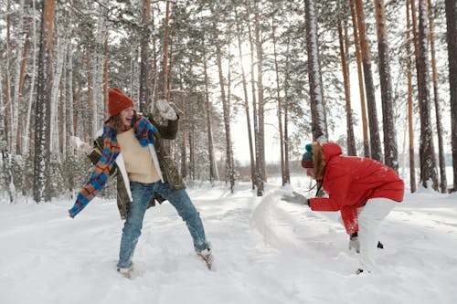 A Woman and a Person Throwing Snow at Each Other