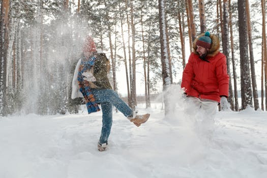 Couple having a fun snowball fight outdoors in a snowy forest, capturing winter joy and togetherness.