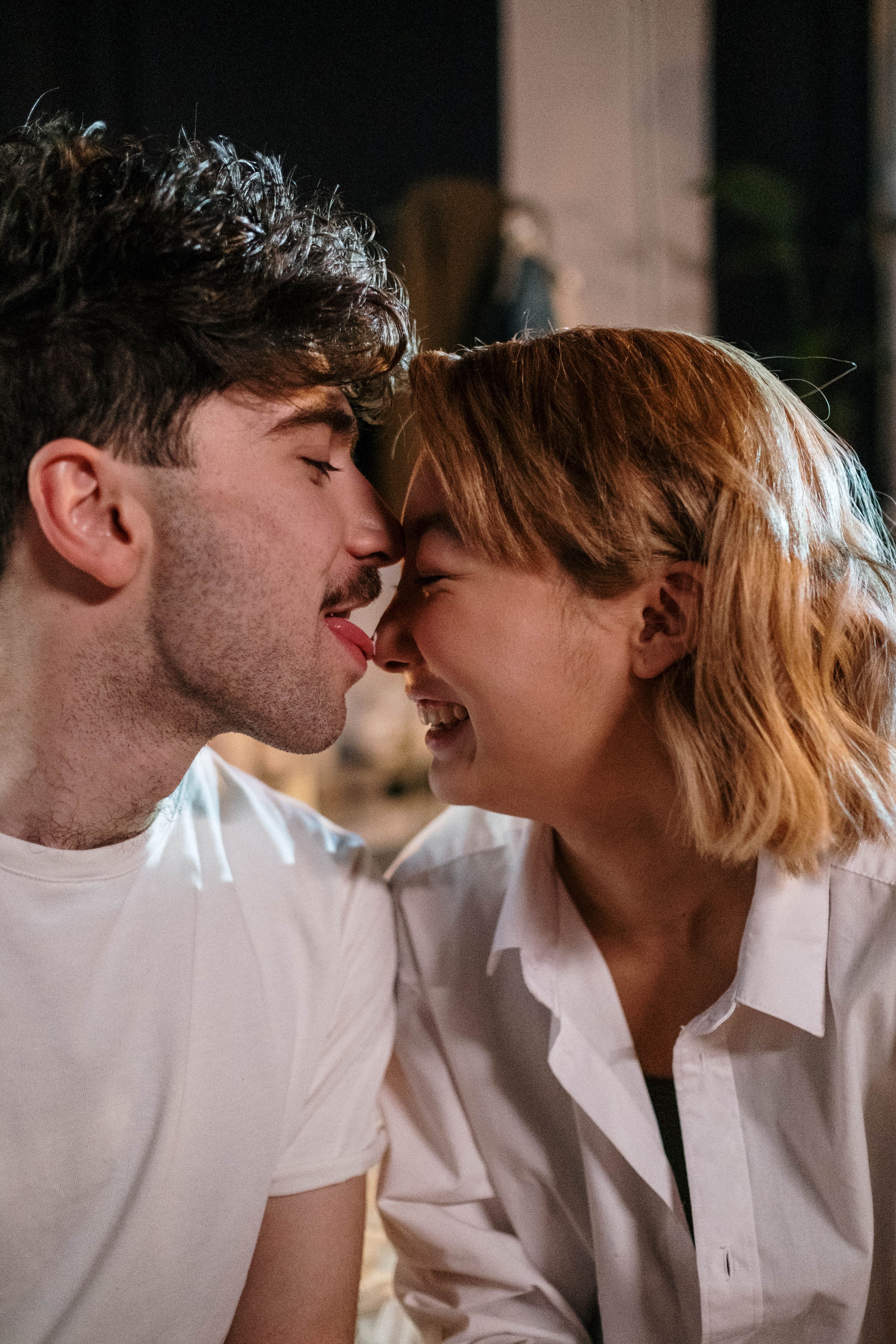 A joyful couple enjoying a playful and intimate moment together indoors, capturing love and happiness.