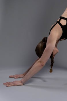 A woman in a yoga pose practicing the downward dog position in an indoor setting.