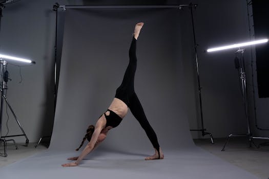 Adult woman executing yoga pose in professional studio with balanced lighting.