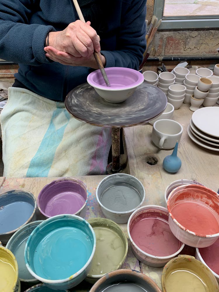 A Person Painting A Ceramic Bowls