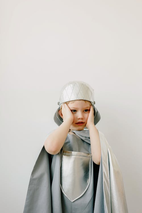 Free Kid Wearing a Knight Costume with Hands on Face Stock Photo