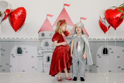 Free Children in Costumes Standing Beside a Castle Wall Painting Stock Photo