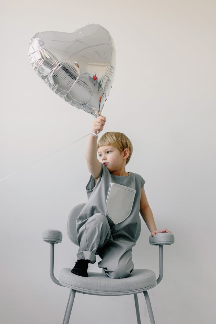 Child Holding A Heart Shaped Balloon