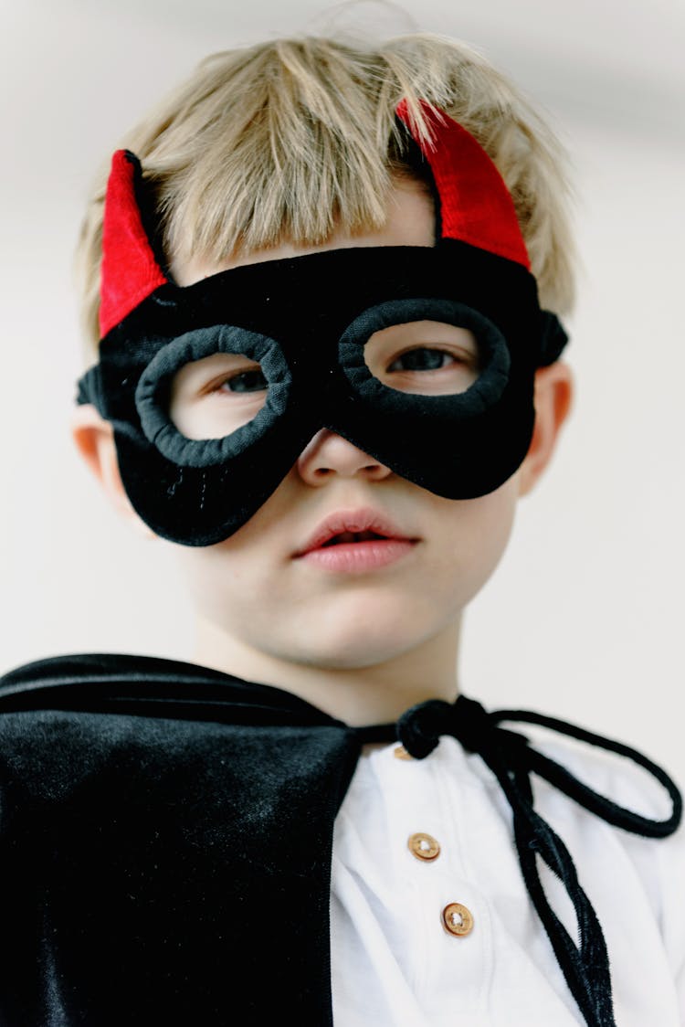 A Boy Wearing A Mask With Horns