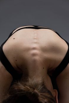 Close-up of woman in yoga pose highlighting spine